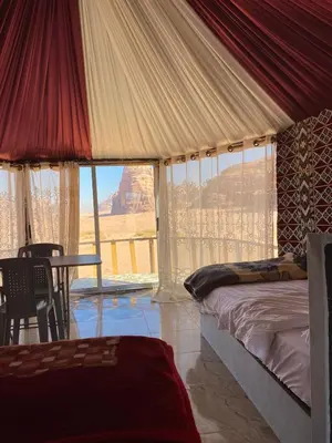 a bedroom with a bed and a view of the grand canyon at Desert guide camp in Wadi Rum