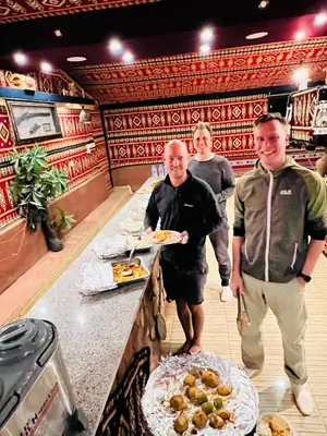 a group of men standing at a counter in a restaurant at wadi rum bedouin stars camp in Wadi Rum