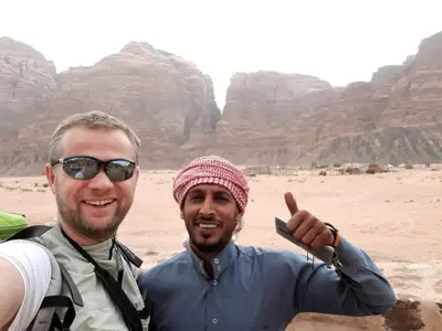 two men posing for a picture in the mountains at wadi rum bedouin stars camp in Wadi Rum