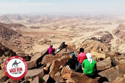 a group of people sitting on top of a mountain at Wadi Rum Desert Base Camp in Wadi Rum