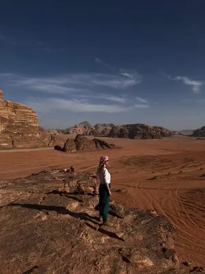 a woman standing on a rock in the desert at Beduin Star Trail Camp in Wadi Rum