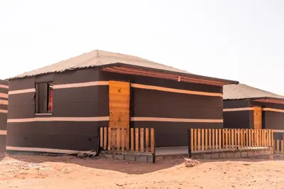 a black house with a fence in front of it at Beduin Star Trail Camp in Wadi Rum