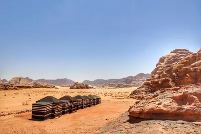 a row of black containers in the desert at Beduin Star Trail Camp in Wadi Rum