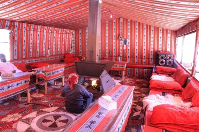 a person sitting in a room with a fire in it at Beduin Star Trail Camp in Wadi Rum