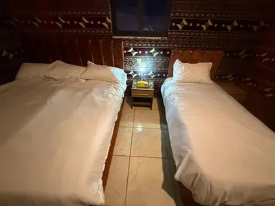 two beds sitting next to each other in a room at Khazali Mountain Camp in Wadi Rum