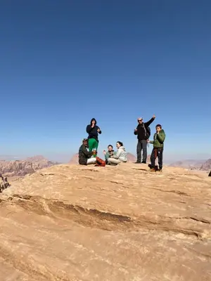 a group of people standing on top of a mountain at Khazali Mountain Camp in Wadi Rum