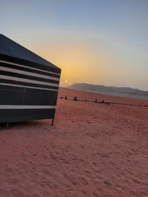 a bench on a beach with the sunset in the background at bedouin future camp in Wadi Rum
