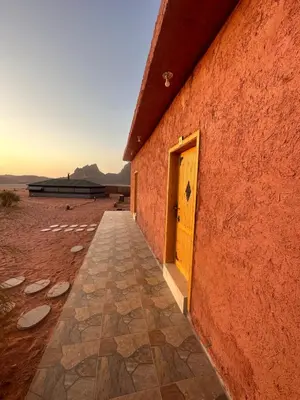 a orange building with a yellow door on the side at bedouin future camp in Wadi Rum