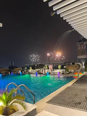 a swimming pool at night with fireworks in the background at mass paradise2 in Aqaba