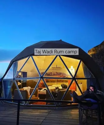 a man is sitting in a igloo tent at Taj Wadi Rum camp in Wadi Rum