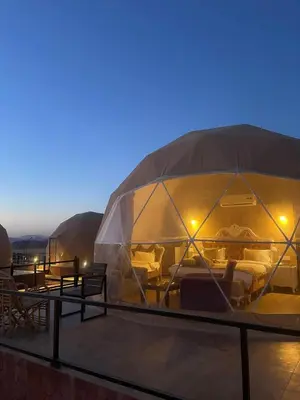 a large domed tent with couches and tables on a roof at Taj Wadi Rum camp in Wadi Rum