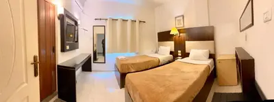 a hotel room with two beds and a mirror at Petra Town Check-Inn in Wadi Musa