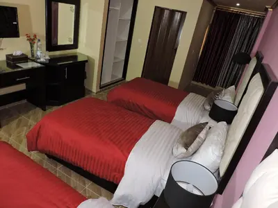 a hotel room with two beds and a mirror at Valentine Inn Luxury in Wadi Musa