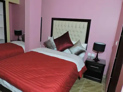 a bedroom with two beds with red and white at Valentine Inn Luxury in Wadi Musa