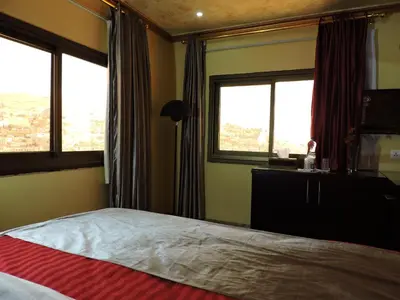 a bedroom with a bed and two windows at Valentine Inn Luxury in Wadi Musa