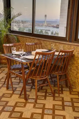 a wooden table and four chairs on a patio at Laverda Hotel in Aqaba