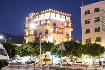 a tall building with cars parked in front of it at Laverda Hotel in Aqaba