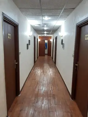 an empty hallway in an office building with wooden floors at Amman Ambiance Hotel in Amman