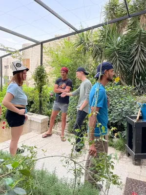 a group of people standing in a garden at Battuta Hostel in Amman