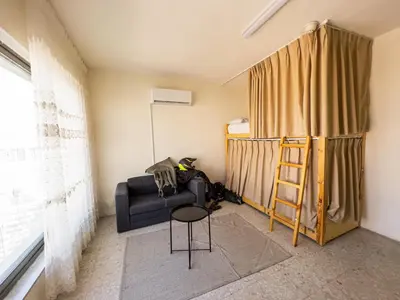 a living room with a couch and a ladder at Battuta Hostel in Amman