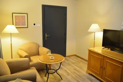 a living room with a tv and a couch and a table at The Y Hotel in Amman