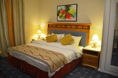 a hotel room with a large bed with two lamps at The Y Hotel in Amman