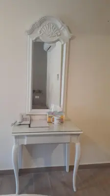 a white dressing table with a mirror on it at Layaali Amman Hotel in Amman
