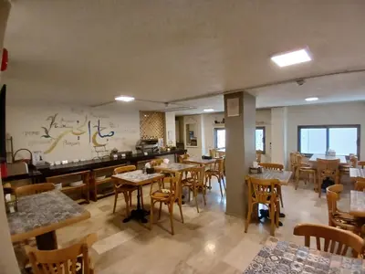 a restaurant with tables and chairs in a room at Layaali Amman Hotel in Amman