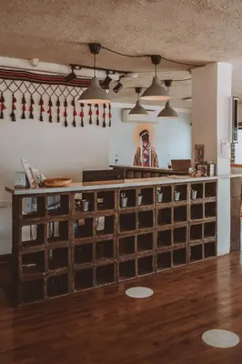 a man in a hat standing behind a counter in a room at Nomads Hotel in Wadi Musa