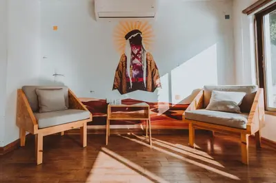 a living room with two chairs and a painting on the wall at Nomads Hotel in Wadi Musa