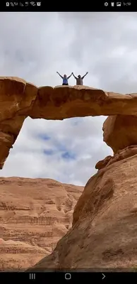 two people standing on a bridge in the desert at مخيم الجبال البرونزية in Wadi Rum
