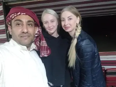 a man and two women posing for a picture at مخيم الجبال البرونزية in Wadi Rum