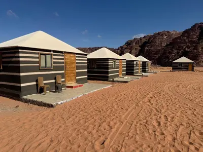 a row of camp huts in the desert at Myra Stars Camp & Tours in Wadi Rum