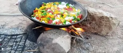 a pan of food cooking on top of a fire at Wateen Home in Wadi Musa