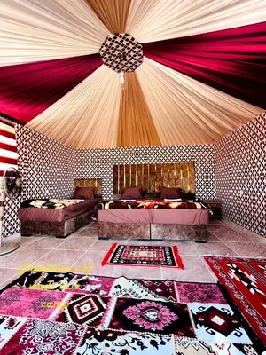 a room with two beds and a room with a ceiling at Traditions of Wadi Rum camp & jeep tour in Wadi Rum