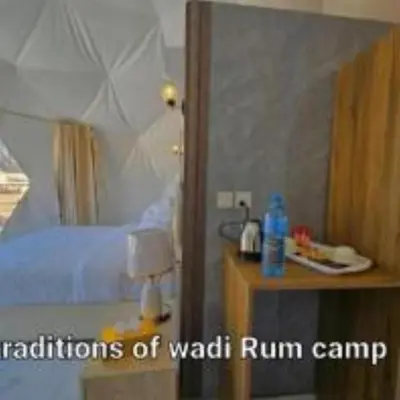 a bedroom with a bed and a table with a mirror at Traditions of Wadi Rum camp & jeep tour in Wadi Rum