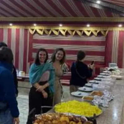 two women standing in front of a table with food at Traditions of Wadi Rum camp & jeep tour in Wadi Rum