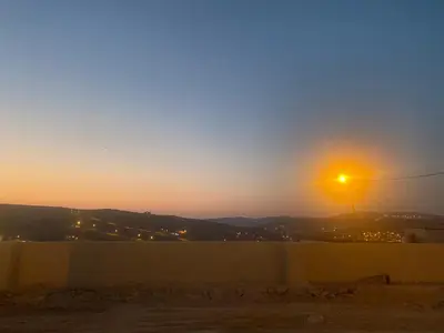 a sunset view of a street light over a fence at Darkum Apartment in Wadi Musa