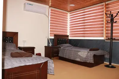 a bedroom with two beds and a window at Basant Villa in Wadi Musa