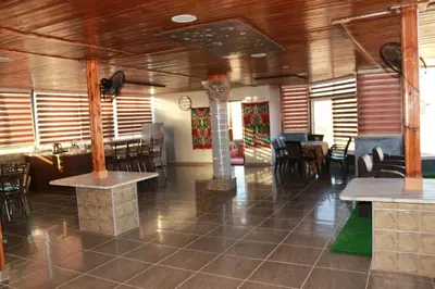 a restaurant with wooden ceilings and tables and chairs at Basant Villa in Wadi Musa