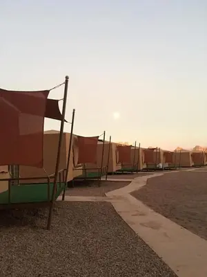 a row of tents with tables and chairs at Zeina Desert Lodge in Wadi Rum