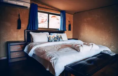 a large bed in a room with a window at Zeina Desert Lodge in Wadi Rum