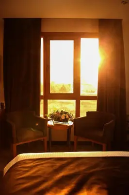 a bedroom with a window and a table and chairs at Gloria Hotel Amman in Amman