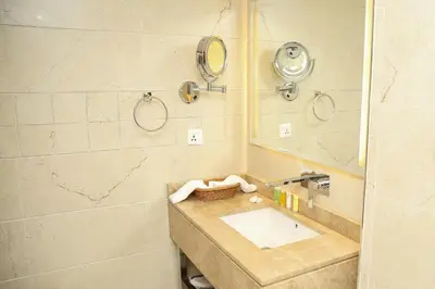a bathroom with a sink and a mirror at Gloria Hotel Amman in Amman