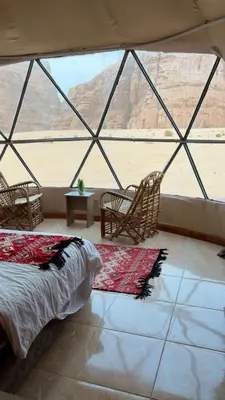 a bedroom with a bed and a view of the desert at Zarb Desert Camp in Wadi Rum