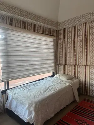a bedroom with a bed and a window with blinds at Wadi rum Bedouin Experience in Wadi Rum