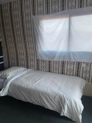 a bed in a bedroom with a window with a white bedspread at Wadi rum Bedouin Experience in Wadi Rum