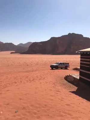 a truck parked in the middle of the desert at Wadi rum Bedouin Experience in Wadi Rum