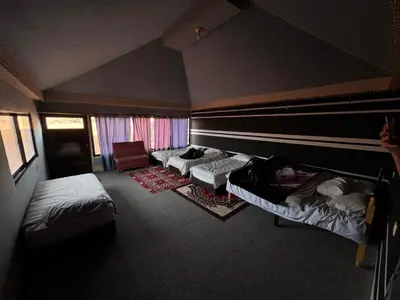a room with three beds and a chair and a room with at Wadi rum Bedouin Experience in Wadi Rum