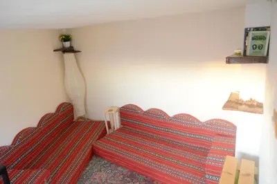 a living room with two red couches in a room at Our Villa's Pine Cottage - HQ Budget Stay - Wonderful horizon view of Jerash in Jerash